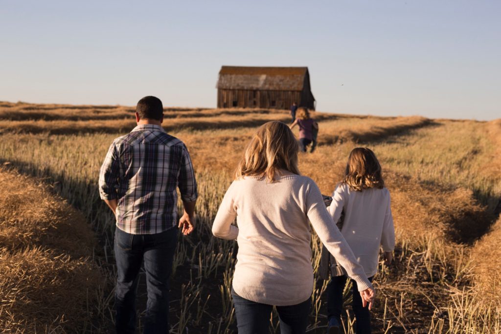 Familia de espaldas andando por un campo